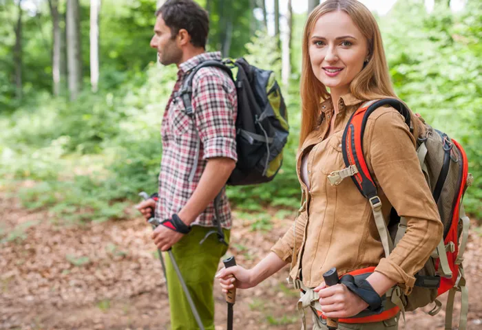 Couple faisant de la marche nordique en foret