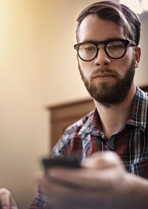 Jeune homme branché utilisant son téléphone portable.